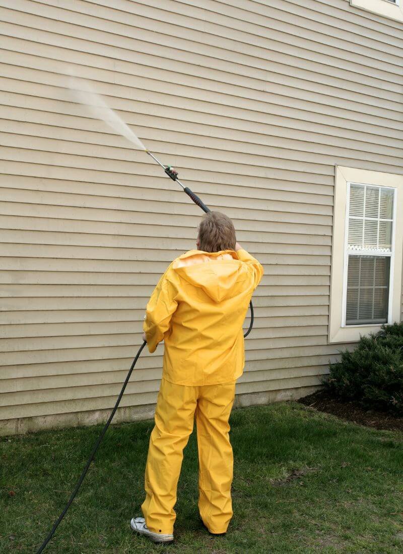 An expert of bestpressurewashingfl pressure washing the siding of a house.